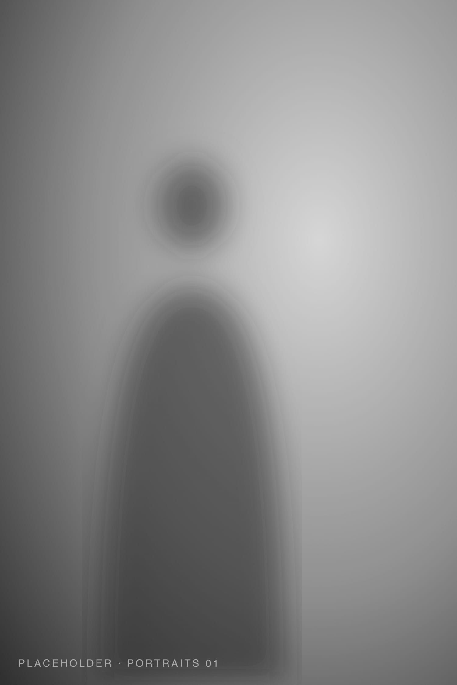 Black and white studio portrait, lit from one side against a grey backdrop